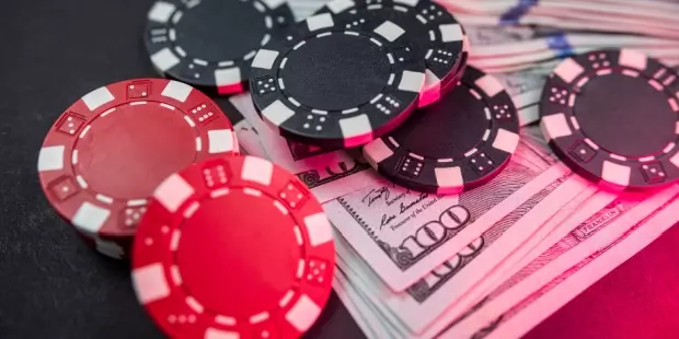 poker chips lying on a stack of cash