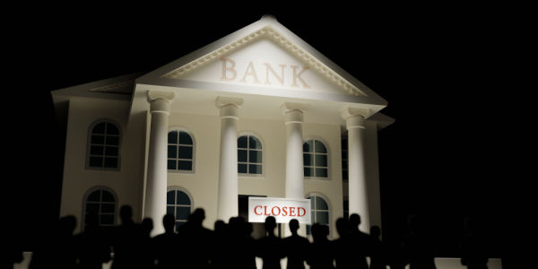 People standing in front of a closed bank.