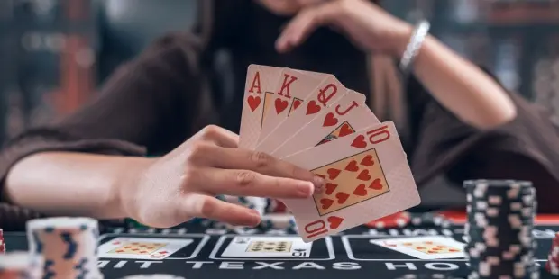 A woman playing poker, holding a royal flush hand.