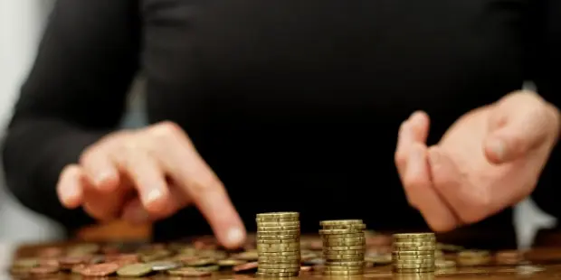 A woman counting stacks of coins.