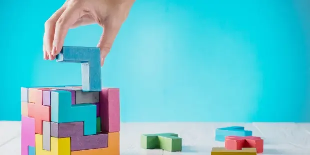A woman stacking wooden blocks on top of each other.