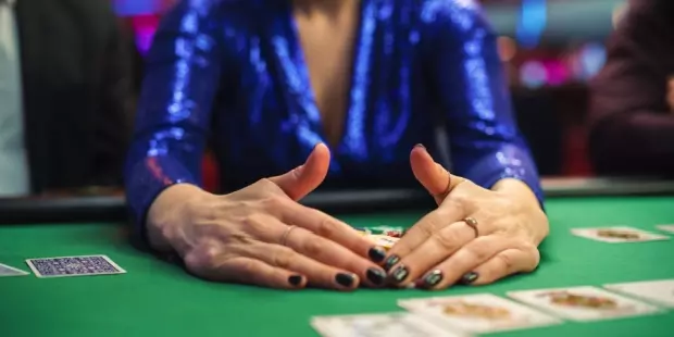 A woman collecting poker chips after winning a poker game at a casino. 