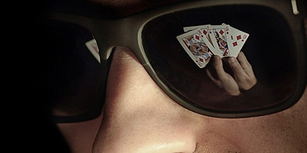 A Royal Flush of diamonds reflected in the sunglasses of a player