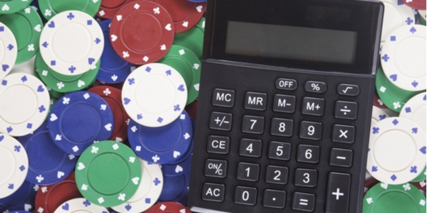 a calculator on the table surrounded by poker chips