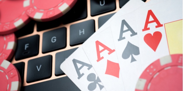 casino chips and 4 Aces sitting on a laptop keyboard