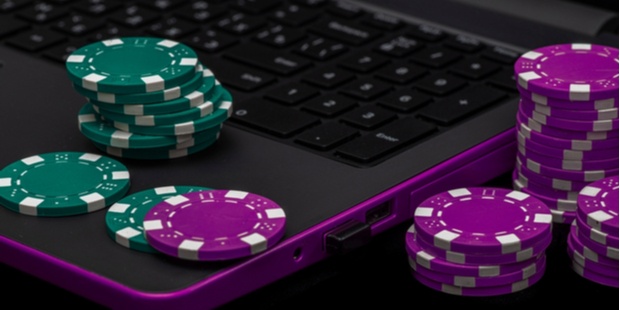 A few stacks of poker chips lying on and near a laptop. 