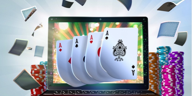 Four aces appear on a computer screen, surrounded by piles of poker chips.