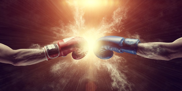 A picture of two hands with boxing gloves on, touching before a fight. 