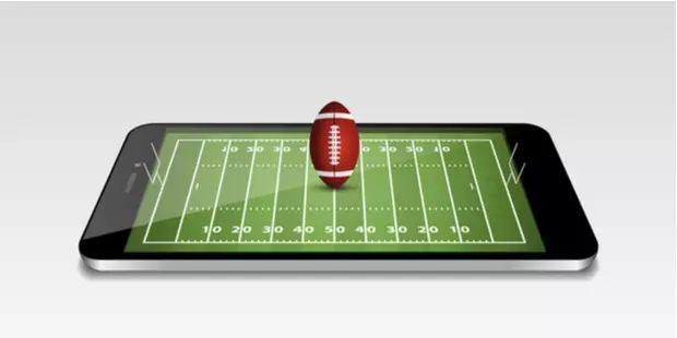 football field on a mobile phone with a football balanced on top