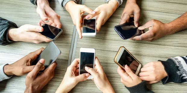 group of friends playing on their mobile phones