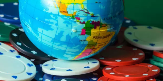 A model of the earth's globe placed on a stack of poker chips.