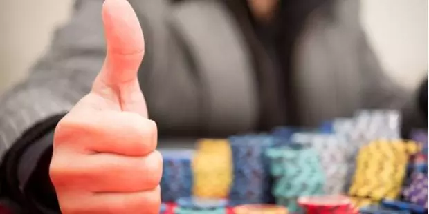 a player with lots of poker chips showing thumbs up sign