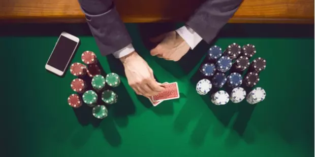 poker table full of chips, cards and a mobile phone