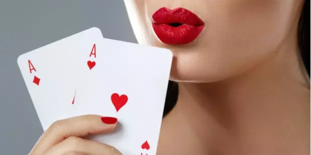 Two aces being held by a woman with red lipstick