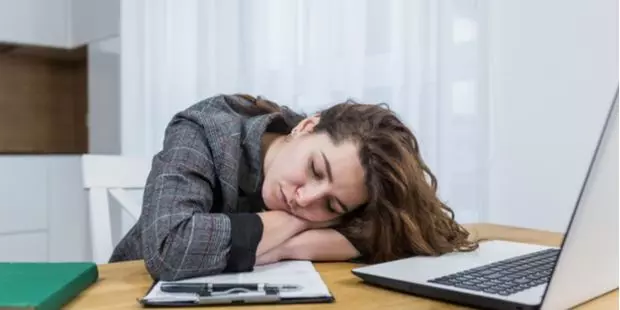 A woman falling asleep in front of her computer. 