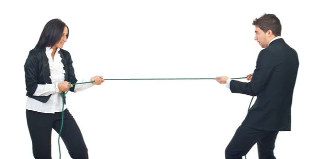 A man and a woman pulling each other back and forth in a tug-of-war