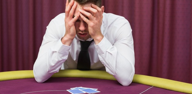 a devastated player seated at a poker table