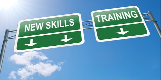 "New skills" and "training" written on highway signs, with a clear sky in the background. 