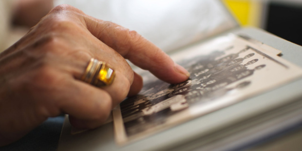 A woman's hand touching an old photo in an album.