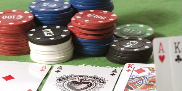 poker table with two Aces and a King as the flop and poker chips around