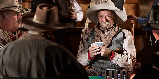 Poker player at a poker table wearing a cowboy hat