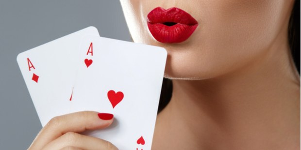 Two aces being held by a woman with red lipstick